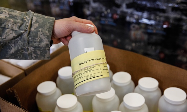  The national guard hand out water testing jugs for residents at a fire station on Thursday in Flint, Michigan.